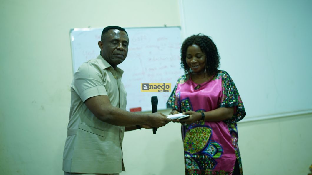 Mr. Endi Ezengwa presenting cash gift to Mrs Chigozirim Uche, the best staff award